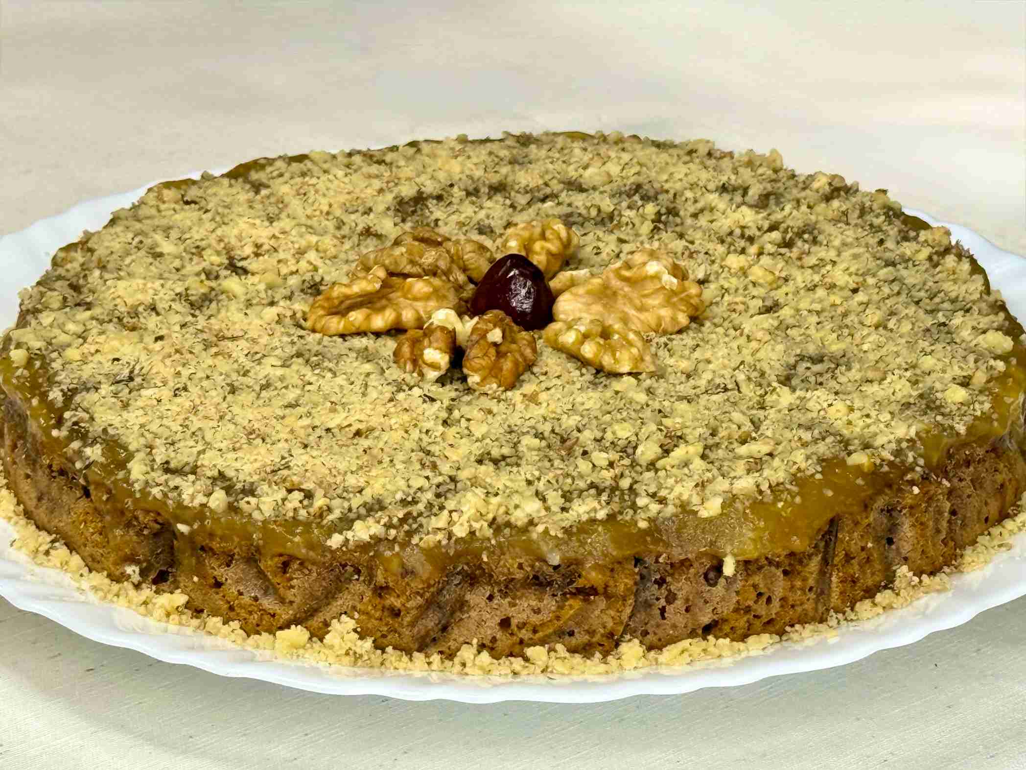 Posni manastirski kolač sa orasima, marmeladom od jabuka i cimetom, serviran na tanjiru.